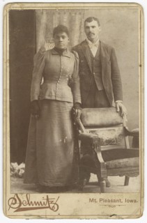 Photograph of an African-American couple standing behind a chair, ca. 1890. Creator: Schmitz Studio.