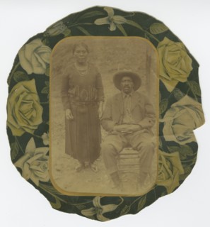 Photographic portrait of a man and woman on floral paper backing, early 20th century. Creator: Unknown.