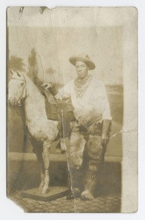 Postcard of a man posing in a Western scene in a photography studio, early 20th century. Creator: Unknown.
