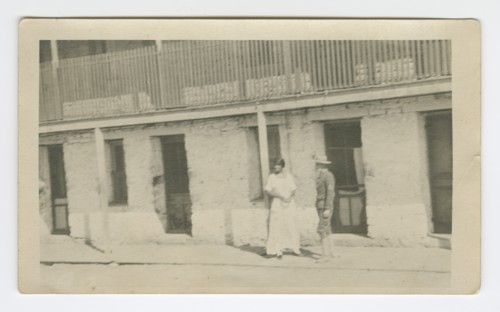 Photograph of a man and woman standing on a sidewalk, early 20th century. Creator: Unknown.