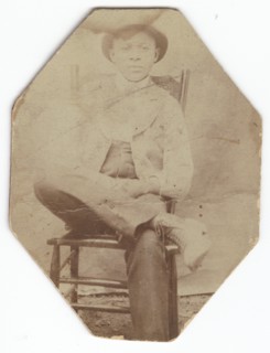 Photographic print of a man in suit sitting on a chair with right leg crossed, late 19th-early 20th  Creator: Unknown.