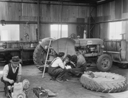 Laing workers carrying out maintenance work on the a Fordson Major Diesel Tractor, 22/07/1959. Creator: John Laing plc.