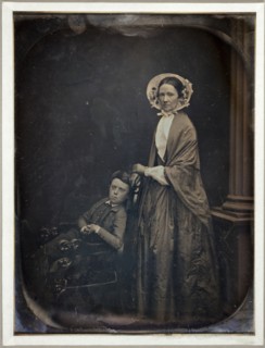Untitled (A Woman in Bonnet and Shawl, with her Seated Son), c. 1850. Creators: Albert Sands Southworth, Josiah Johnson Hawes.
