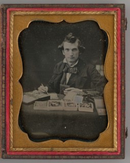 Untitled (Portrait of Seated Man Holding a Daguerreotype and Brush), 1865. Creator: Samuel J. Miller.
