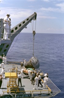 Gemini 5 capsule hoisted onboard recovery ship, 1965. Creator: NASA.