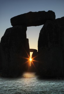View of Stonehenge, showing the sun's rays glinting through the opening in a trilithon, 2012. Creator: James O Davies.