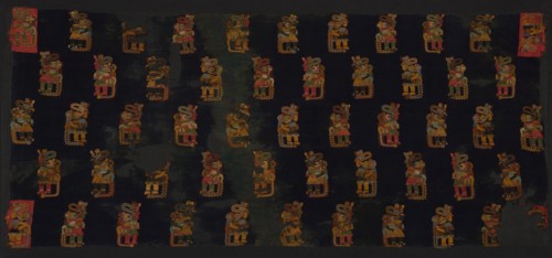 Mantle, Peru, 100 B.C./A.D. 200. Human figure motif wearing headdress, ear ornaments, and carrying a pampas cat. Both humans and cats have protruding tongues.