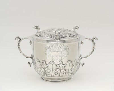 Two-Handled Covered Cup, 1698/1720. Silver cup with lid, two handles with leaf designs, used to serve syllabub, a sweetened or flavoured wine, cider, beer, or ale into which milk was whipped. Scroll-l...