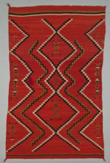 Sarape with Terraced Zigzag Design, 1865/85. A work made of wool, plain weave and dovetail tapestry weave; twined warp ends and selvages; looped and knotted corner tassels.