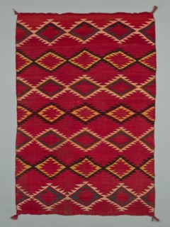Sarape with Serrated Diamond Pattern, 1880/1900. A work made of wool, plain weave with "lazy lines" and dovetail tapestry weave; twined warp ends and selvages; looped and knotted corner tassels.