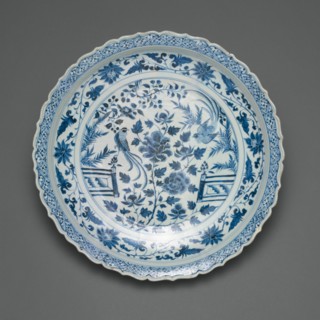 Shallow Dish with Long-Tailed Birds in a Garden of Stylized Peonies and Fronds, Encircled by a Scrolling Wreath of Camellia and Lotus Blossoms, Yuan dynasty (1279-1368), early/mid-14th century.