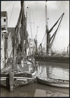 Sailed fishing vessels moored beside timber warehouses at Rochester, Medway, 1925-1935. Creator: J Dixon Scott.