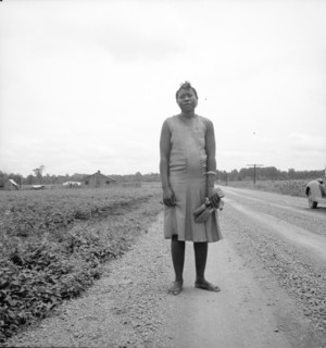 Negro woman carrying her shoes home from church, Mississippi Delta, 1936. Creator: Dorothea Lange.
