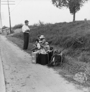 A hitchhiking family waiting along the highway in Macon, Georgia, 1937. Creator: Dorothea Lange.