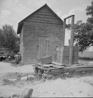 Well and old plantation smokehouse, Chesnee, South Carolina, 1937. Creator: Dorothea Lange.
