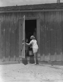 Child of Texas sharecropper carrying water, 1937. Creator: Dorothea Lange.