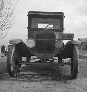 Model T Fords still carry migrants, FSA migratory labor camp at Farmersville, California , 1939. Creator: Dorothea Lange.