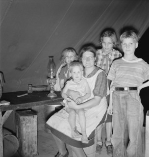 Family of six in tent after supper, FSA mobile unit, Merrill, Klamath County, Oregon, 1939 Creator: Dorothea Lange.