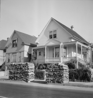 Woodpiles along the street are a characteristic of Portland, Oregon, 1939. Creator: Dorothea Lange.