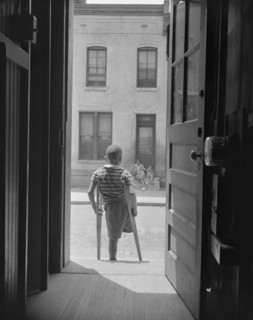 Young boy standing in the doorway of his home on Seaton Road...,Washington, D.C, 1942. Creator: Gordon Parks.