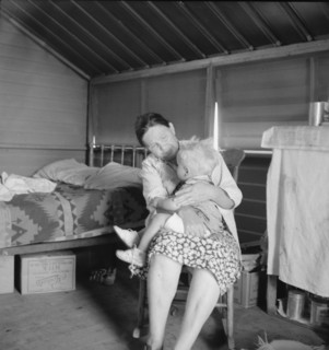 Mother from Oklahoma tends baby with dysentery, FSA camp, Tulare County, CA, 1939. Creator: Dorothea Lange.
