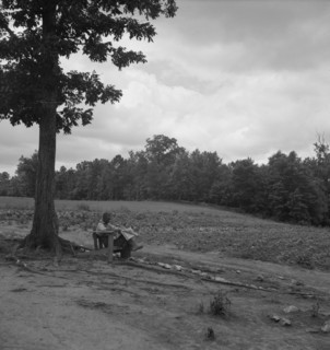 Negro tenant farmer reading paper on a hot Saturday afternoon, Chatham County, North Carolina, 1939. Creator: Dorothea Lange.