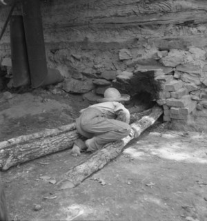 Ten year old son of tobacco tenant tends the fire..., Granville County, North Carolina, 1939. Creator: Dorothea Lange.