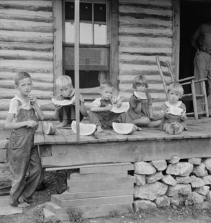 Millworker's children eating watermelon on porch of rented house, Person County, N Carolina, 1939. Creator: Dorothea Lange.