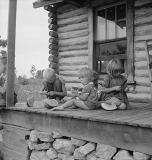 Millworker's children eating watermelon on porch..., Person County, North Carolina, 1939. Creator: Dorothea Lange.