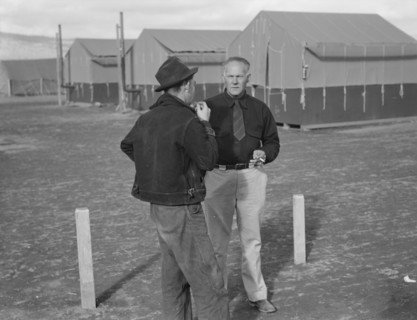 Camp manager talking to another man, FSA mobile camp, Merrill, Klamath County, Oregon, 1939. Creator: Dorothea Lange.