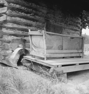 Tobacco barn with tobacco sled and vehicle used..., Person County, North Carolina, 1939. Creator: Dorothea Lange.