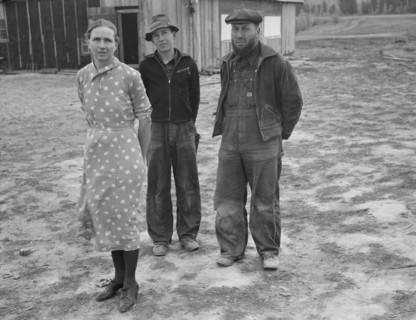 The mother, father, and hardworking fifteen-year-old son in yard..., Boundary County, Idaho, 1939. Creator: Dorothea Lange.
