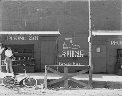 Shoeshine stand, Southeastern U.S. [Sign: 'Shine - Bennie Sims'. On bicycle: City Shine Parlour'].