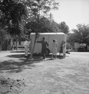 Between Tulare and Fresno on U.S. 99. Family inspect a house trailer with idea of purchase.