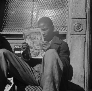 Washington, D.C. Negro youth reading a funny paper on a door step in the Southwest section.