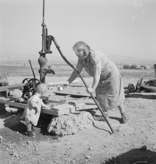 Mrs. Soper with youngest child at the well. Willow creek area, Malheur County, Oregon.
