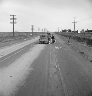 Passing motorist gives walking family of seven a lift to the next town. California.