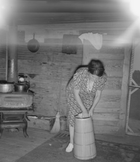 Wife of tobacco sharecropper cleaning butter churn. Person County, North Carolina.