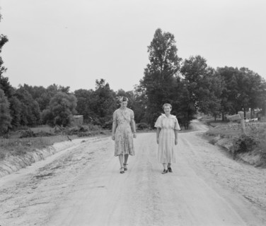 Women walking down the road to see a sick neighbor. Person County, North Carolina.