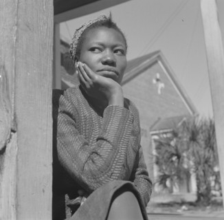 Daytona Beach, Florida. Woman sitting on her porch on Sunday morning.