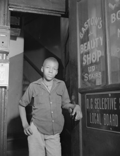 Washington, D.C. Youth waiting for a newspaper delivery truck.