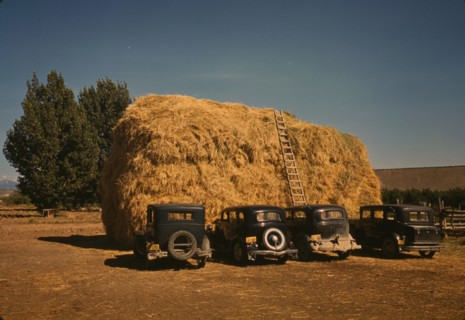Hay stack and automobile of peach pickers, Delta County, Colorado, 1940. Creator: Russell Lee.