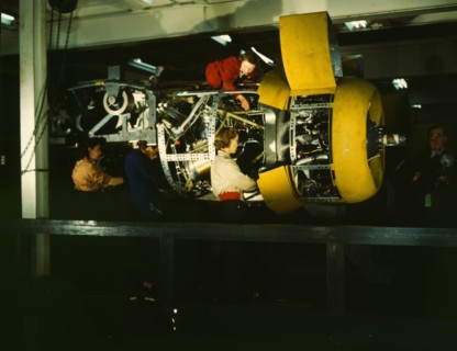 Installing one of the 4 motors on the transport plane at Willow Run, between 1941 and 1945. Creator: Howard Hollem.