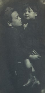 Young boy holding a smaller child, c1900.
