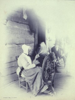 Elderly woman sitting on porch spinning, c1894.