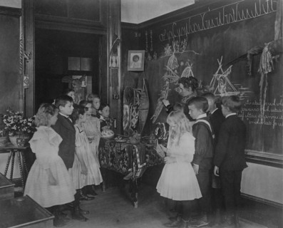 Teacher showing students Native American handicrafts at a school in Washington, D.C., (1899?).