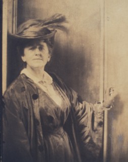 Gertrude Ka¨sebier, wearing feathered hat, standing, facing front, half-length portrait, c1900. Creator: Adolph de Meyer.