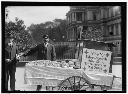 Peanut vendor Steve Vasilakas standing near his cart..., between 1916 and 1918. Creator: Harris & Ewing.