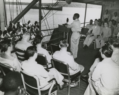 African American chaplain standing at the podium and conducting the religious service..., 1939 - 194 Creator: United States Coast Guard.