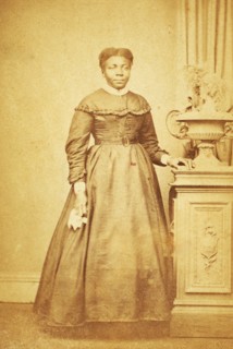 Studio portrait of unidentified  woman holding handkerchief, c1860-c1869. Creator: Sims Photograph Gallery.